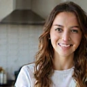 Mujer joven sonriendo, con un fondo de cocina saludable